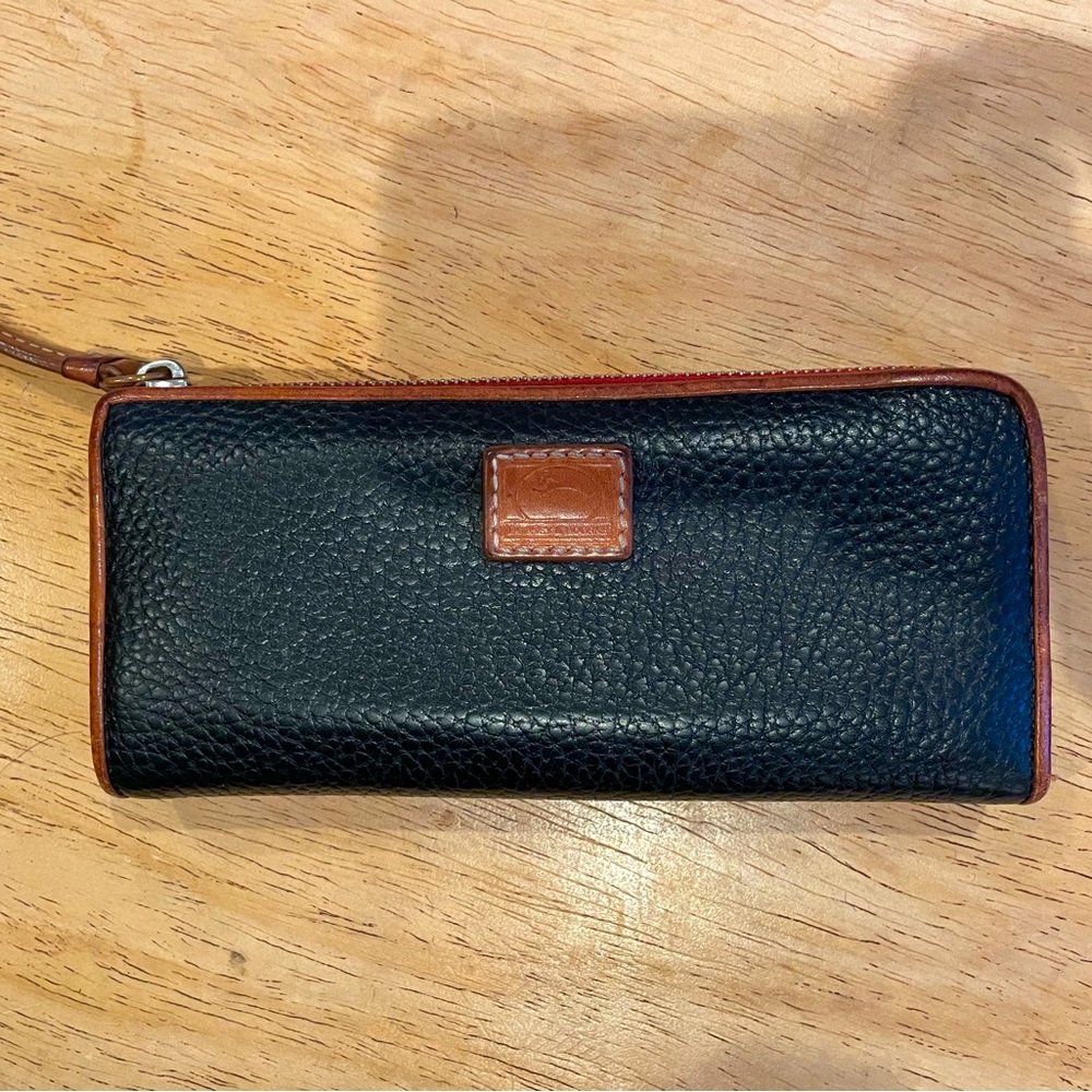 Dooney & Bourke - black leather wallet with brown trim, red inside